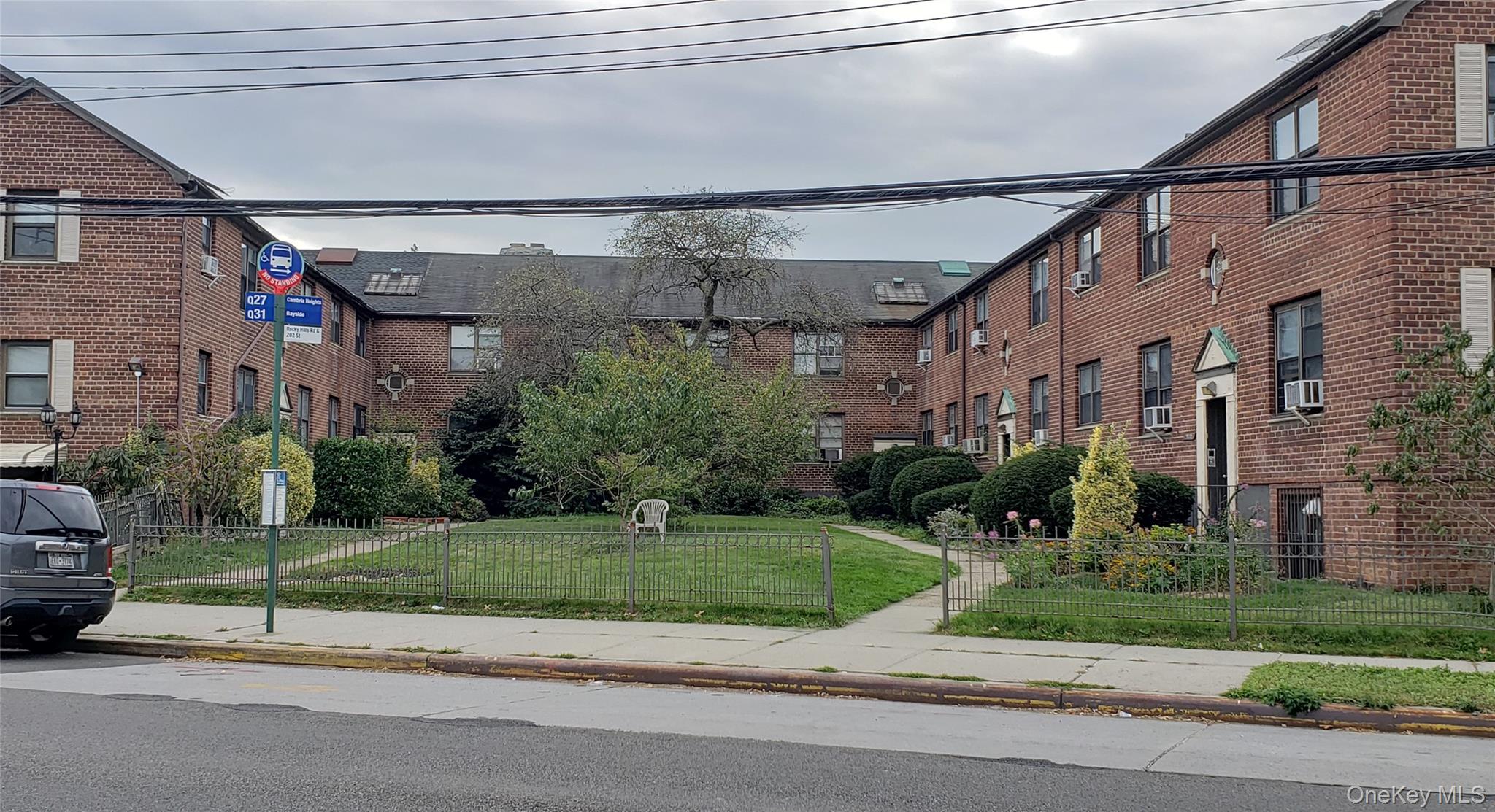 20206 Rocky Hill Road, Unit C1 Queens, NY 11361 - Photo 2 of 17 a view of a big building next to a yard