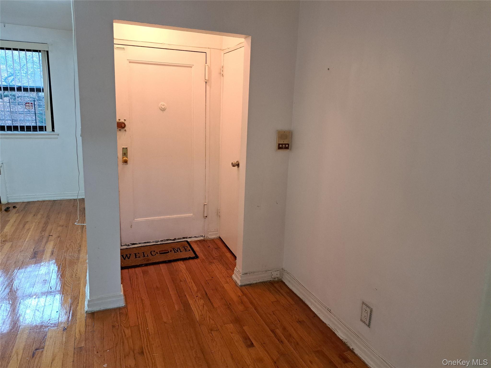20206 Rocky Hill Road, Unit C1 Queens, NY 11361 - Photo 3 of 17 an empty room with wooden floor and a window