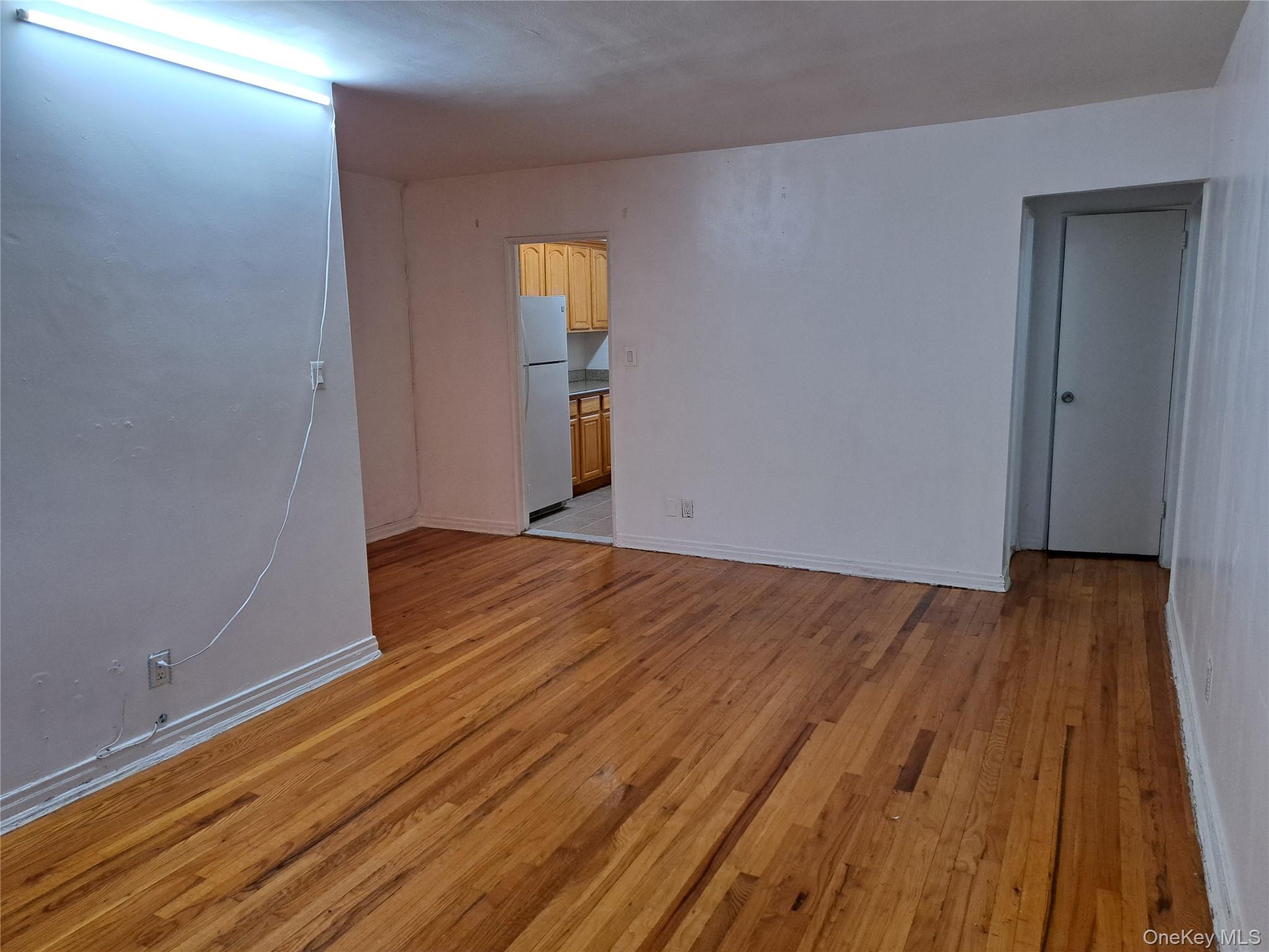 20206 Rocky Hill Road, Unit C1 Queens, NY 11361 - Photo 7 of 17 an empty room with wooden floor and windows