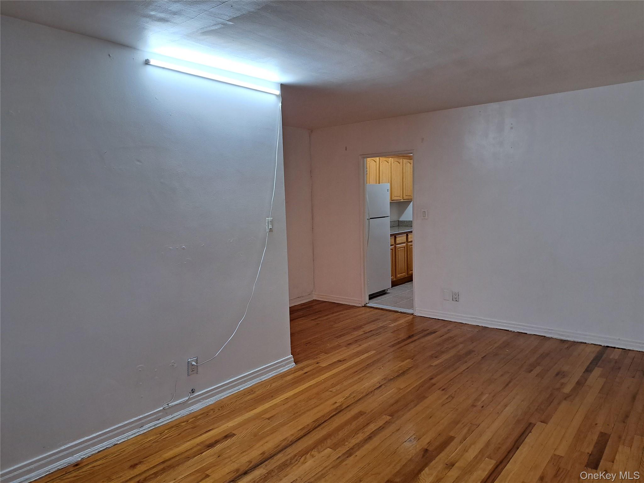 20206 Rocky Hill Road, Unit C1 Queens, NY 11361 - Photo 8 of 17 an empty room with wooden floor and windows