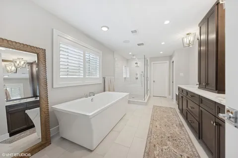 a bathroom with a tub sink and mirror