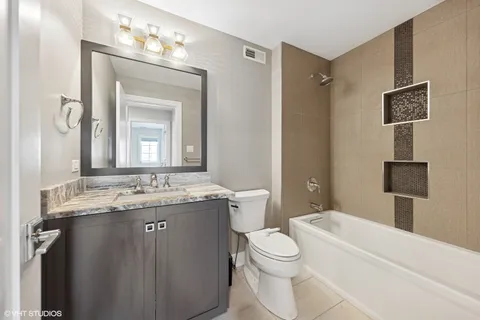 a bathroom with a granite countertop toilet sink and mirror