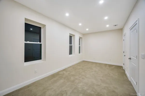 an empty room with windows and closet