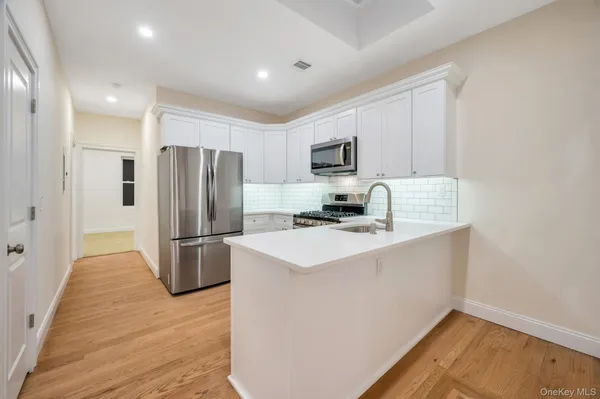 a kitchen with kitchen island a refrigerator sink and stove