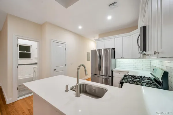 a kitchen with a sink a refrigerator and a stove top oven