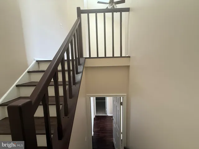 a view of staircase with wooden floor and white walls