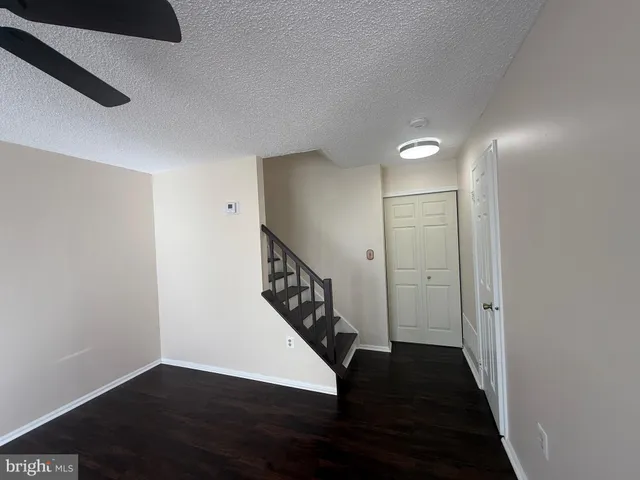 a view of hallway with stairs and wooden floor