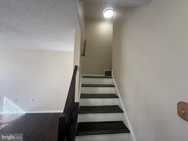 a view of entryway with wooden floor and white walls
