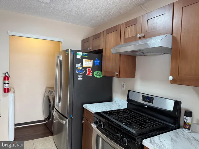 a kitchen with stainless steel appliances granite countertop a refrigerator and a stove top oven