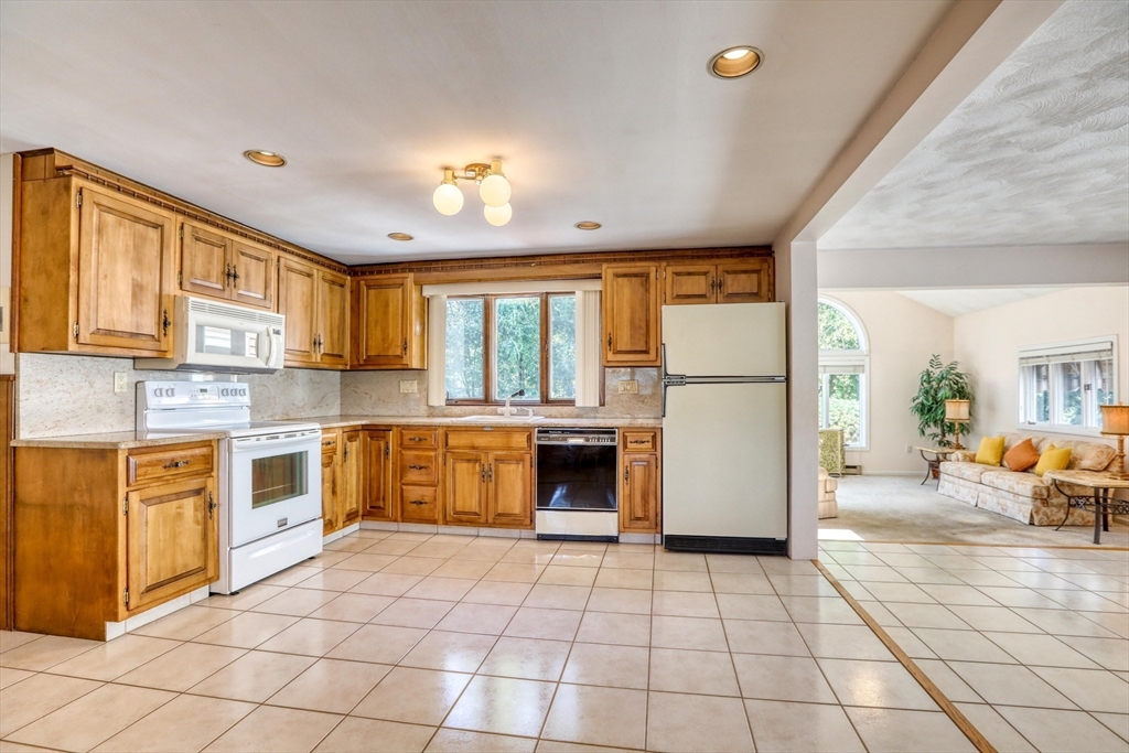 22 Crosby Street Stoneham, MA 02180 - Photo 4 of 30 a large kitchen with a stove a refrigerator and a stove top oven