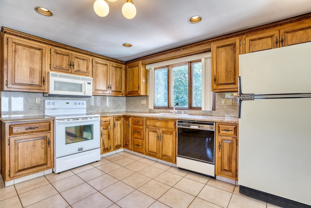 22 Crosby Street Stoneham, MA 02180 - Photo 5 of 30 a kitchen with stainless steel appliances granite countertop a stove a refrigerator and a stove