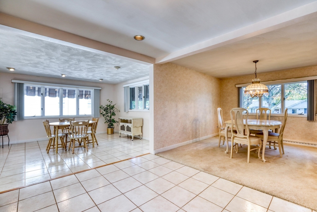 22 Crosby Street Stoneham, MA 02180 - Photo 10 of 30 a dining room with furniture a rug a potted plant and a chandelier