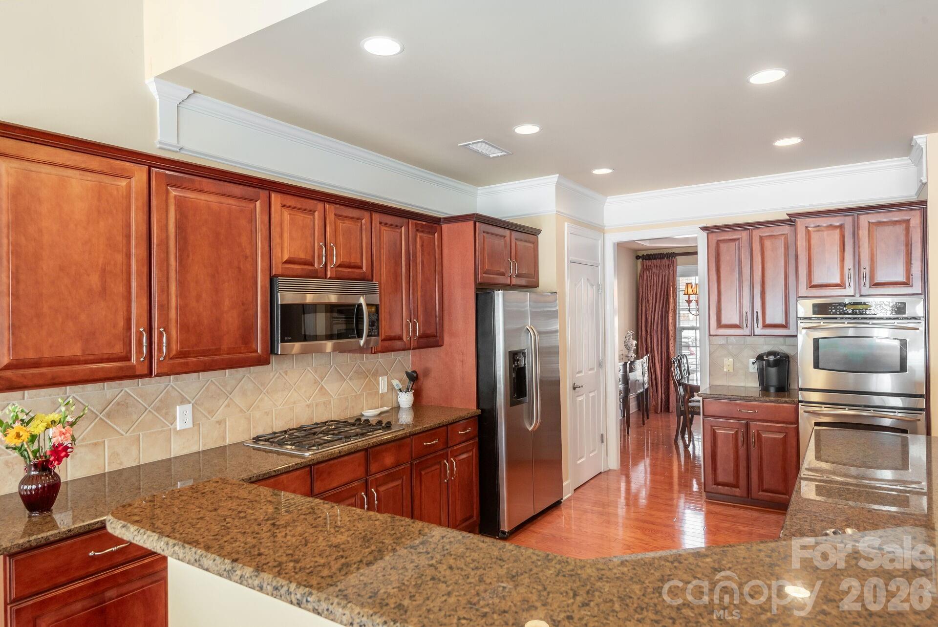 8124 Oratorio Place Charlotte, NC 28270 - Photo 14 of 38 a kitchen with stainless steel appliances granite countertop a refrigerator stove microwave and sink