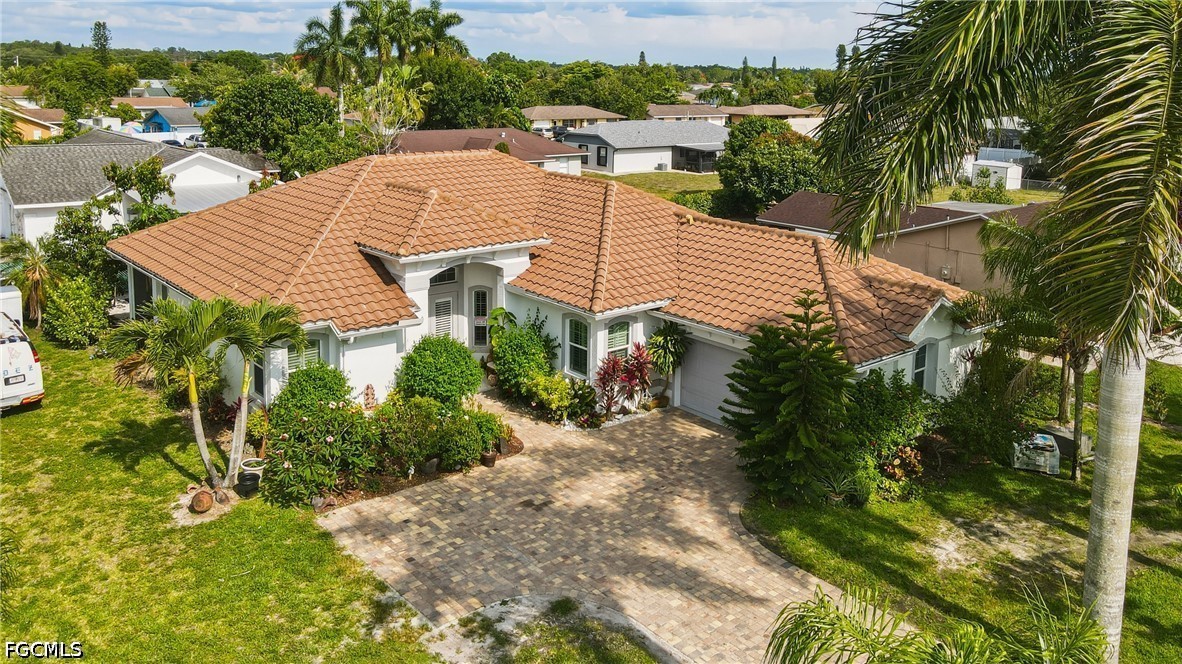 a view of a house with a yard and potted plants