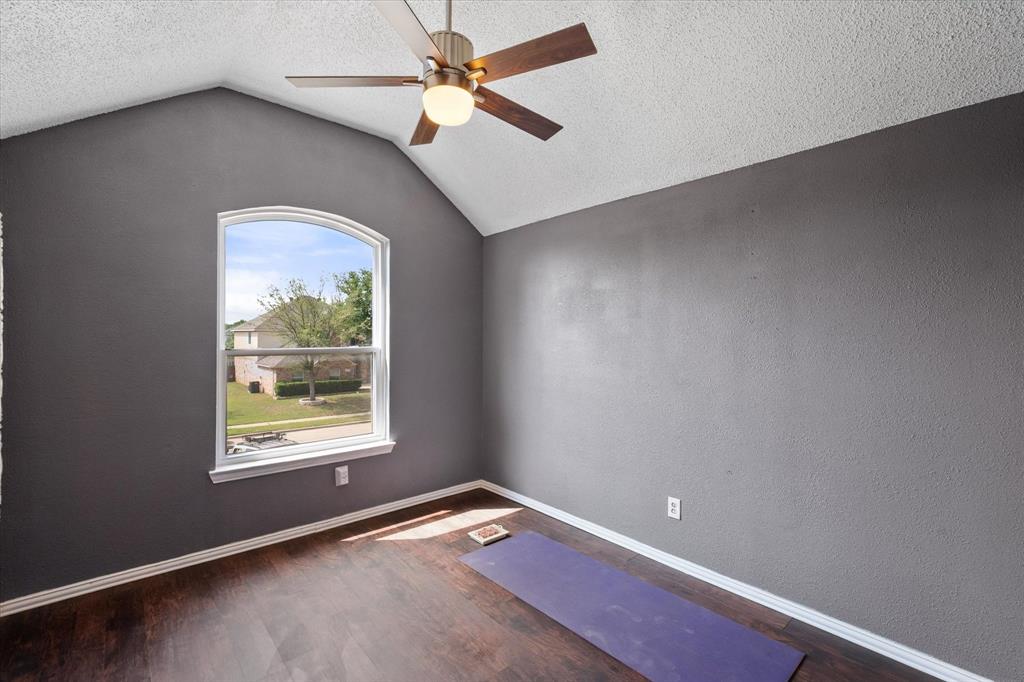 1305 Liverpool Lane Mansfield, TX 76063 - Photo 26 of 40 The room features hardwood floors, a vaulted ceiling, and an arched window