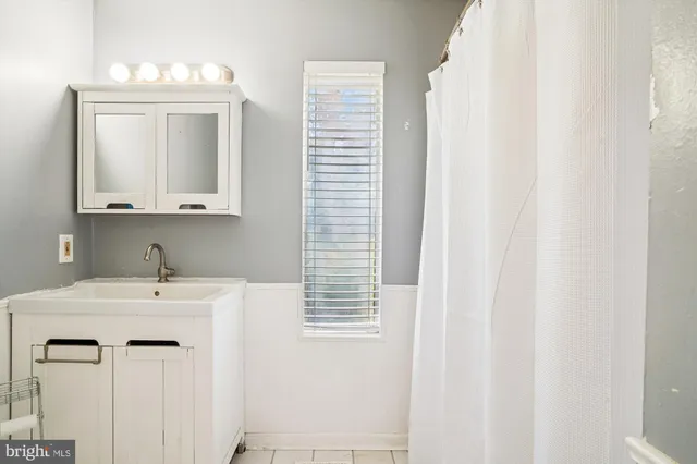 a bathroom with a sink vanity and a mirror