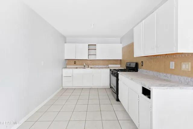 a kitchen with a sink a stove and cabinets