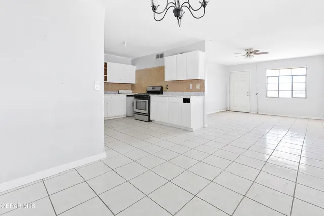 a kitchen with granite countertop white cabinets and window