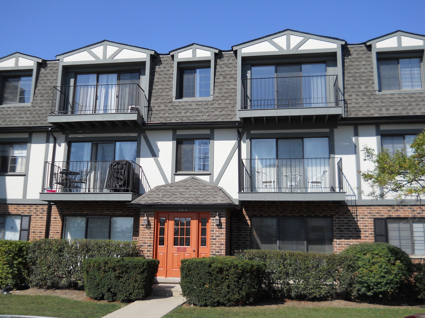 104 Steeple Drive, Unit F Buffalo Grove, IL 60089 - Photo 1 of 11 a front view of a residential apartment building with a yard