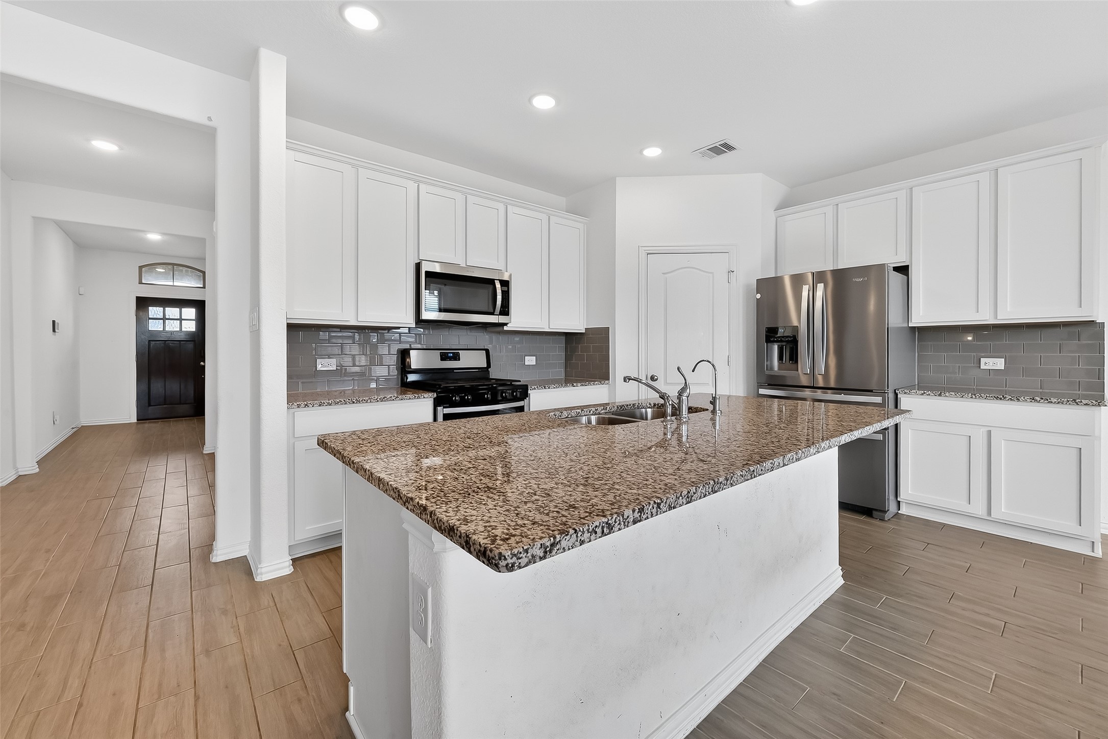31215 Conover Drive Fulshear, TX 77441 - Photo 21 of 42 a kitchen with stainless steel appliances granite countertop a sink a stove and a refrigerator