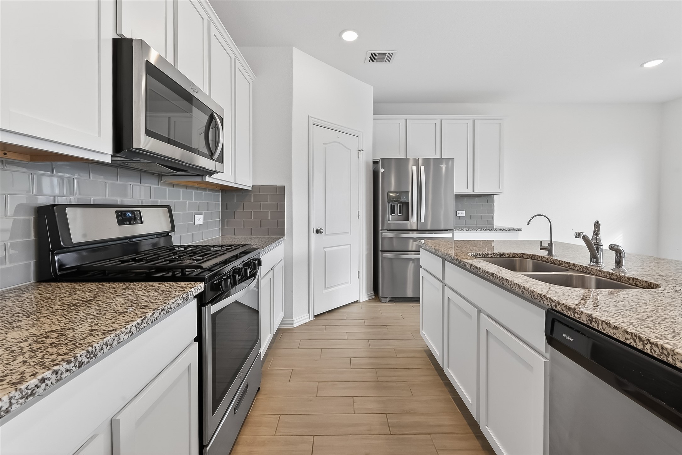 31215 Conover Drive Fulshear, TX 77441 - Photo 22 of 42 a kitchen with stainless steel appliances granite countertop a stove top oven a sink dishwasher and a refrigerator with wooden cabinets