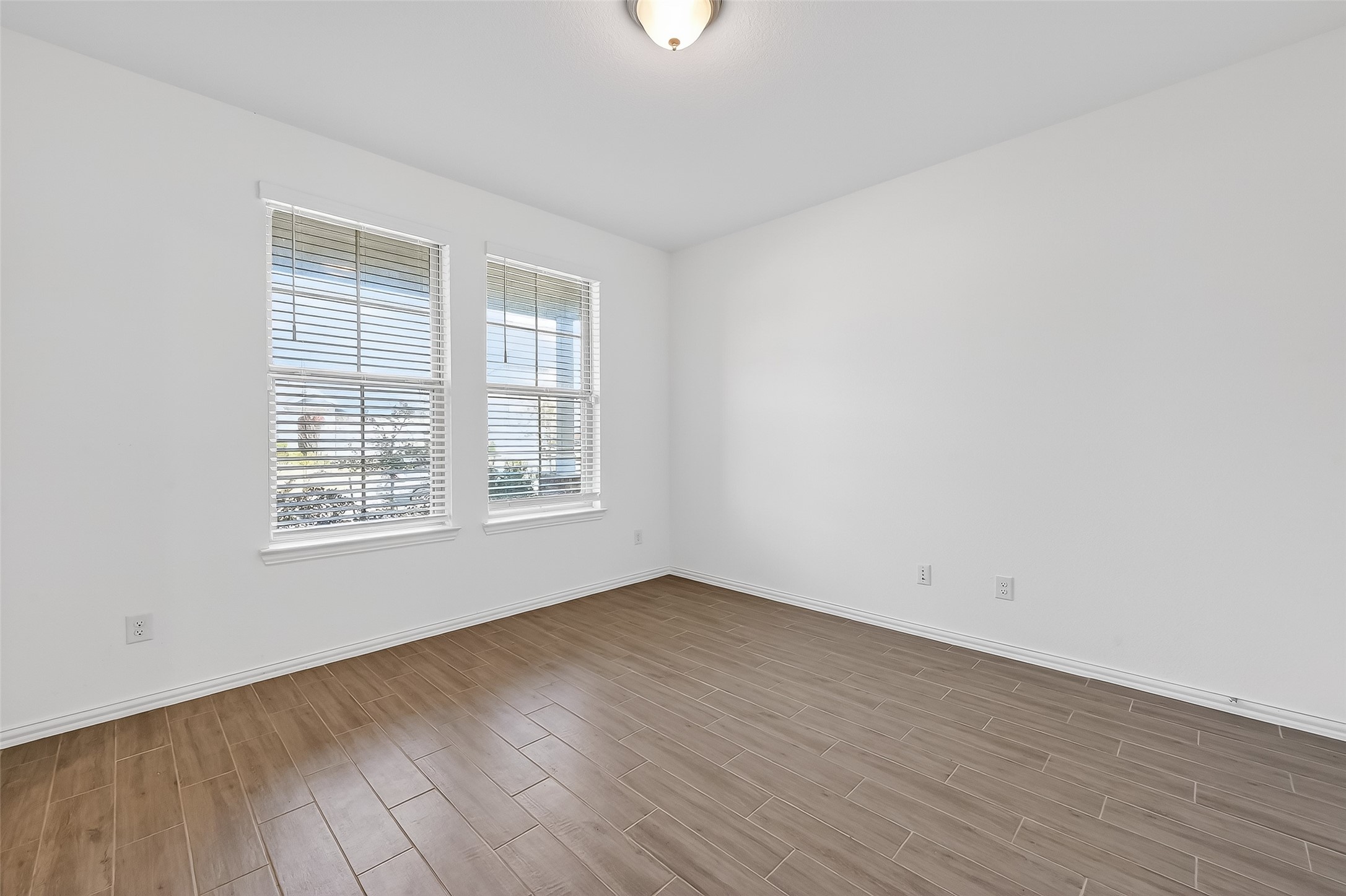31215 Conover Drive Fulshear, TX 77441 - Photo 7 of 42 an empty room with wooden floor and windows