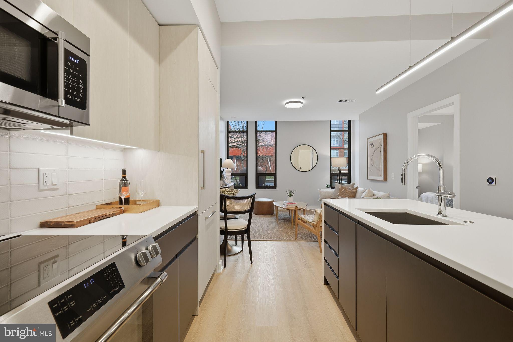 950 3rd Street Northwest, Unit 103 Washington, DC 20001 - Photo 22 of 32 a kitchen with stainless steel appliances a sink stove and cabinets
