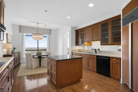 a kitchen with stainless steel appliances granite countertop sink stove top oven and cabinets