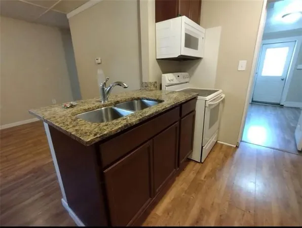 a kitchen with a sink and a wooden floor