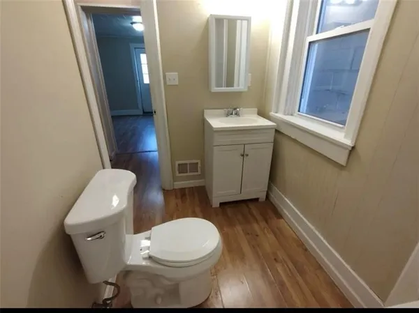 a white toilet sitting next to a bathroom sink and a mirror