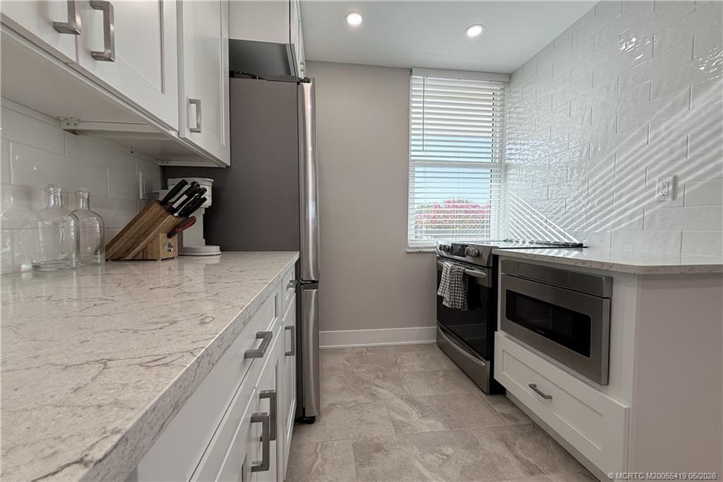 1950 Southwest Palm City Road, Unit 14305 Stuart, FL 34994 - Photo 29 of 70 a kitchen with stainless steel appliances granite countertop a sink and a stove