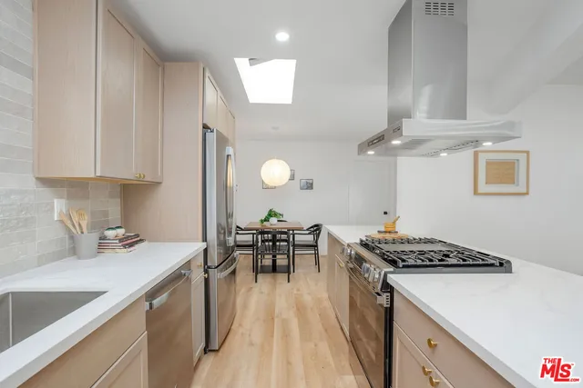 a kitchen that has a sink a stove and chairs
