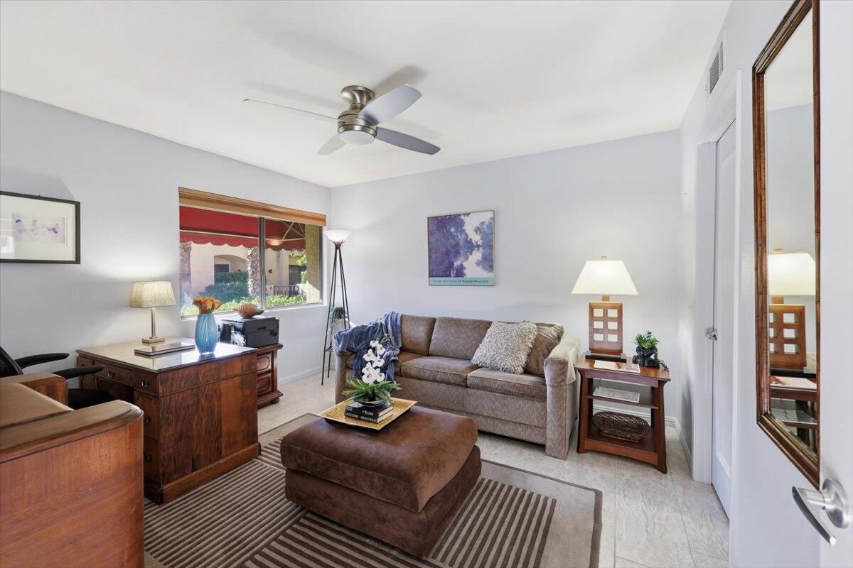 200 East Racquet Club Road, Unit 2 Palm Springs, CA 92262 - Photo 11 of 56 a living room with furniture a lamp paintings and a window