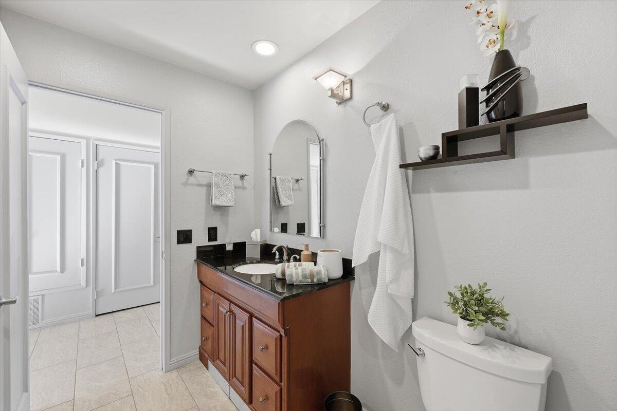 200 East Racquet Club Road, Unit 2 Palm Springs, CA 92262 - Photo 19 of 56 a bathroom with a granite countertop sink a toilet and a mirror