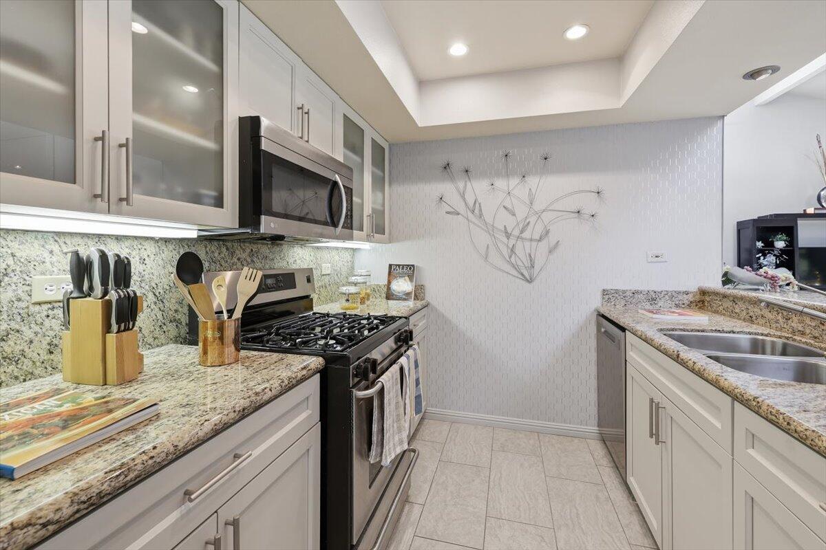 200 East Racquet Club Road, Unit 2 Palm Springs, CA 92262 - Photo 25 of 56 a kitchen with stainless steel appliances granite countertop a sink and a stove