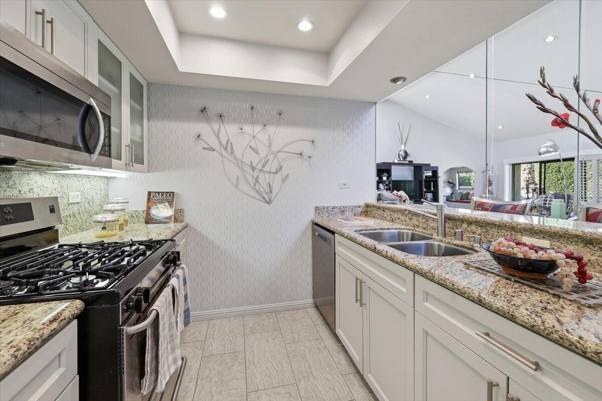 200 East Racquet Club Road, Unit 2 Palm Springs, CA 92262 - Photo 26 of 56 a kitchen with stainless steel appliances granite countertop a sink stove and cabinets
