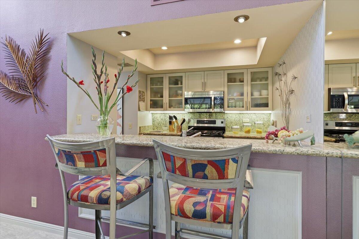 200 East Racquet Club Road, Unit 2 Palm Springs, CA 92262 - Photo 34 of 56 a living room with stainless steel appliances furniture a rug and a kitchen view