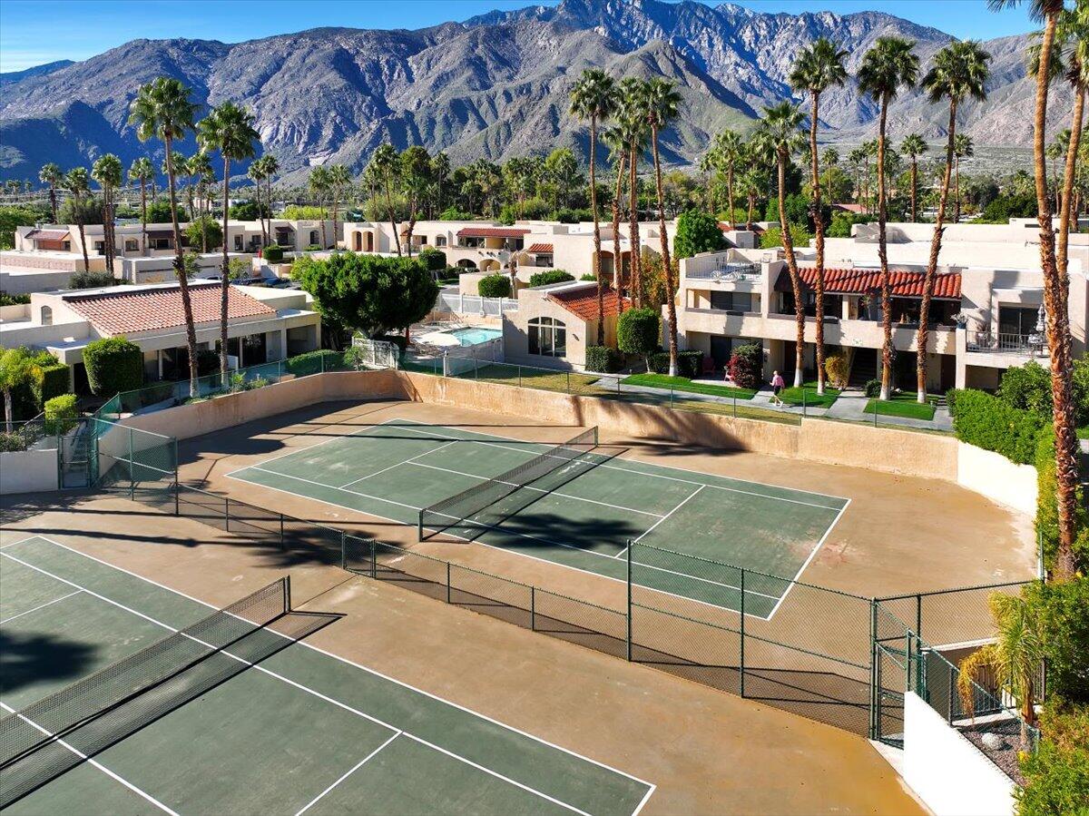 200 East Racquet Club Road, Unit 2 Palm Springs, CA 92262 - Photo 51 of 56 a view of a tennis ground with large trees