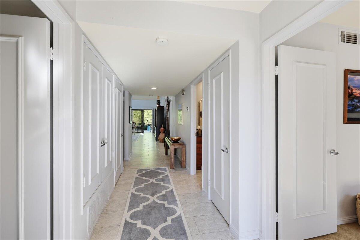 200 East Racquet Club Road, Unit 2 Palm Springs, CA 92262 - Photo 8 of 56 a view of a hallway with closet and a couch