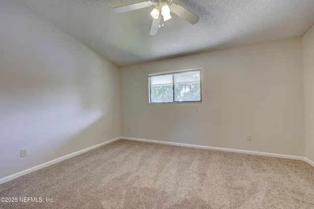 an empty room with a chandelier fan
