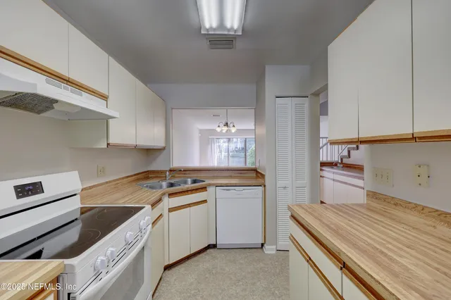 a kitchen with a stove white refrigerator a sink and dishwasher with wooden floor