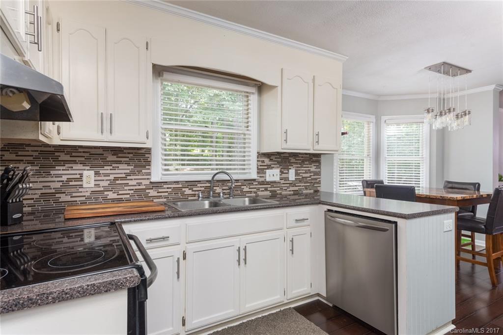1205 Driftway Point Road Matthews, NC 28105 - Photo 7 of 24 a kitchen with stainless steel appliances granite countertop a sink stove and cabinets