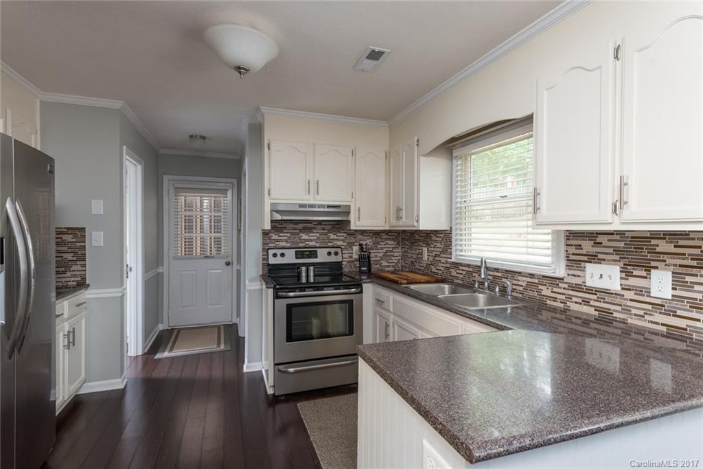 1205 Driftway Point Road Matthews, NC 28105 - Photo 8 of 24 a kitchen with stainless steel appliances granite countertop a sink a stove and a refrigerator