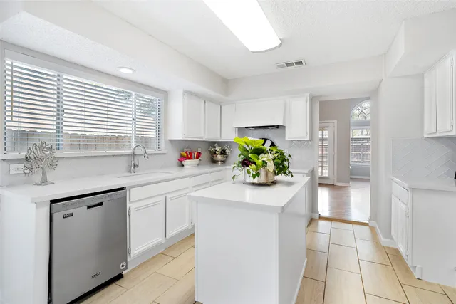 an empty room with windows and ceiling fan