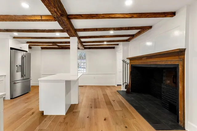 a kitchen with a wooden floor and a fireplace