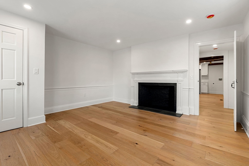 34 Central Street, Unit 1 Rowley, MA 01969 - Photo 17 of 27 a view of empty room with wooden floor and fireplace