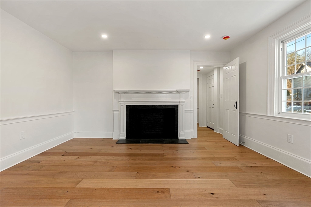34 Central Street, Unit 1 Rowley, MA 01969 - Photo 18 of 27 a view of empty room with wooden floor and fireplace