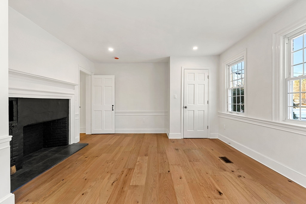 34 Central Street, Unit 1 Rowley, MA 01969 - Photo 22 of 27 a view of empty room with wooden floor and fireplace