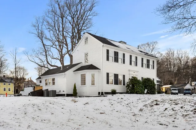 a front view of a house with a yard covered in snow