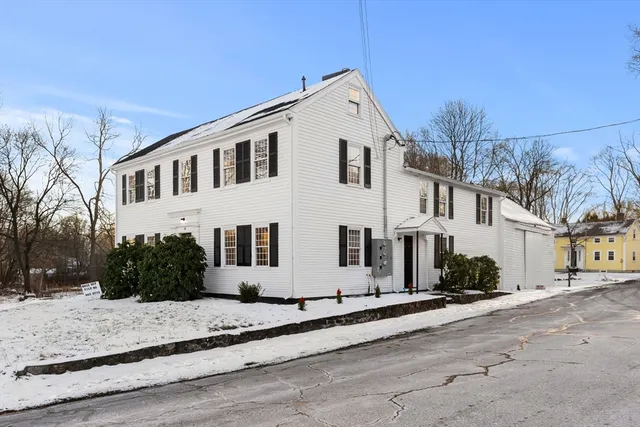 a view of a white house with a yard